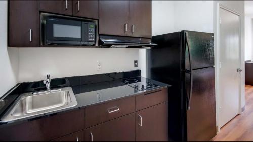 a kitchen with a sink and a microwave and a refrigerator at Motel 6-Channelview, TX in Channelview