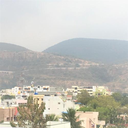 a city with buildings and a mountain in the background at Jayaram Residency Tirupathi in Tirupati