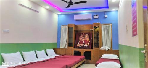 a room with two beds and a ceiling fan at Jayaram Residency Tirupathi in Tirupati
