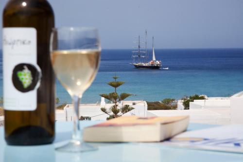 uma garrafa de vinho ao lado de um copo de vinho branco em ALK Hotel em Kamari