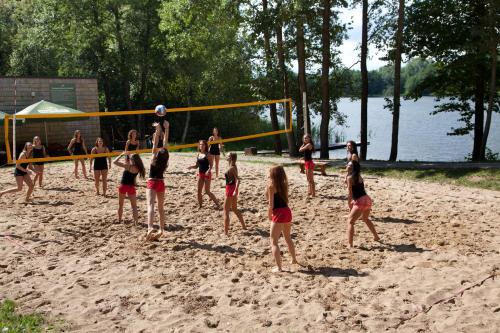 a group of people playing volley ball on a beach at TonyResort in Trakai
