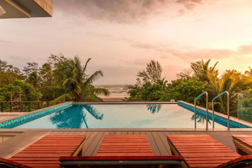 モージムにあるStayVista Ashore 6BHK Infinity Pool Ocean View- Morjimのビーチを望むスイミングプール