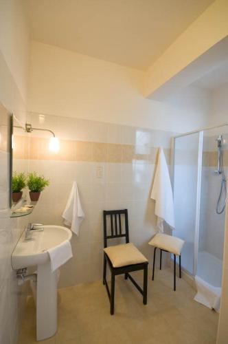 y baño con lavamanos, ducha y silla. en Dormire a Cisanello, en Pisa