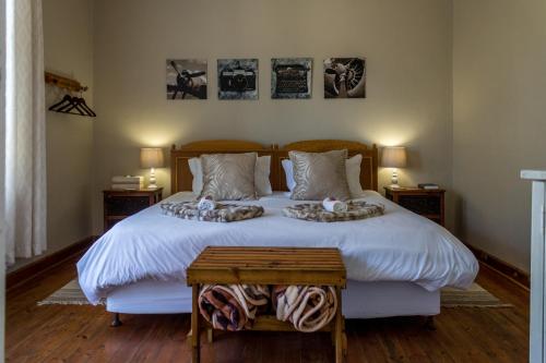 a bedroom with a large white bed with two pillows at Swartberg Guest House in Caledon