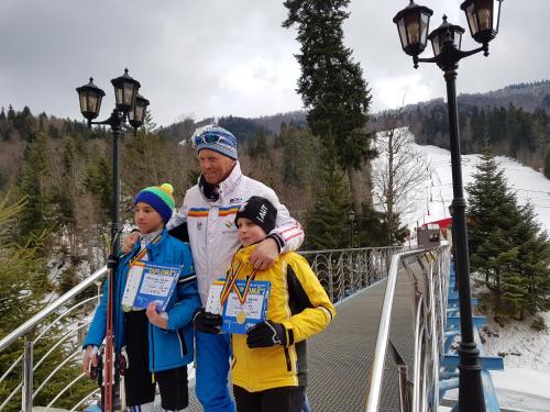 a man and two children standing on a bridge at Vila Alunis in Buşteni