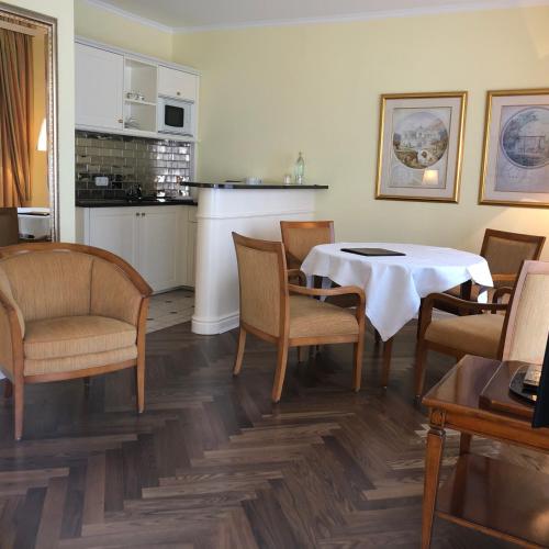 a dining room with a table and chairs and a kitchen at Hotel Scherf in Bad Lippspringe
