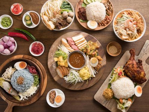 a wooden table with plates of food on it at Resorts World Genting - Crockfords in Genting Highlands