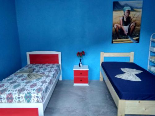 a bedroom with two beds and a blue wall at Ciza e Rose in Portela
