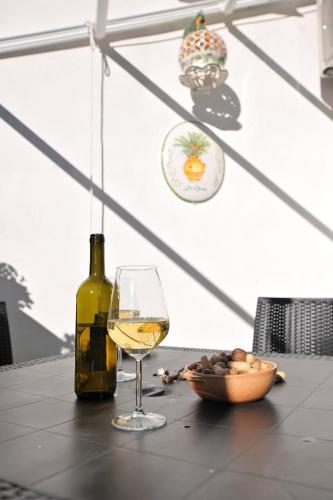 a bottle of wine and a glass on a table at B&b Le Cycas in Castellammare di Stabia