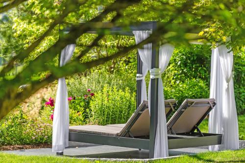 a pair of chairs in a gazebo in a garden at Rieser Achensee Resort in Pertisau