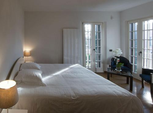a bedroom with a large white bed and a table with flowers at Villa Contarini B&B in Venice-Lido