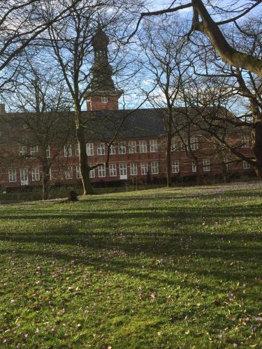 a large brick building with a clock tower in a park at Nordseeperle Husum in Husum