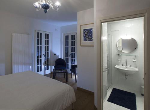 a bedroom with a bed and a sink and a mirror at Villa Contarini B&B in Venice-Lido