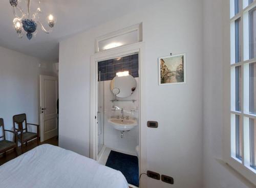 - une chambre blanche avec un lavabo et un lit dans l'établissement Villa Contarini B&B, sur le Lido de Venise
