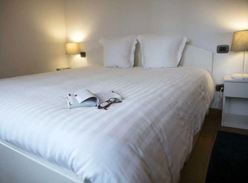 a large white bed with two books on it at Villa Contarini B&B in Venice-Lido
