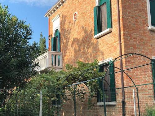 a brick building with a fence in front of it at Villa Contarini B&B in Venice-Lido