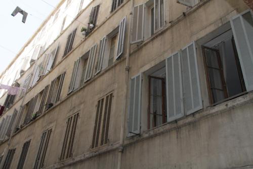 un edificio con ventanas con persianas en un lateral en Massilia en Marsella
