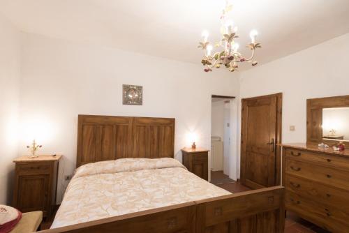 a bedroom with a large bed and a chandelier at Agriturismo Podere Caggiolo - Swimming Pool & Air Conditioning in Marciano