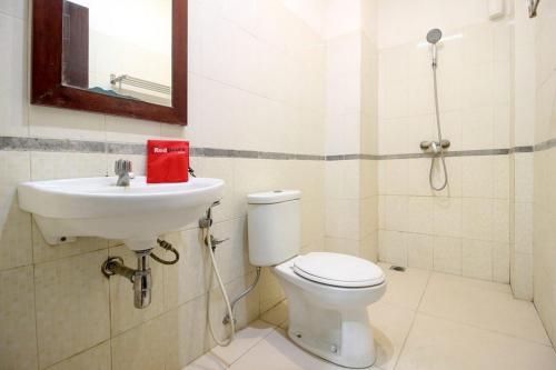 uma casa de banho com um WC e um lavatório em RedDoorz near Stadion Manahan Solo em Solo