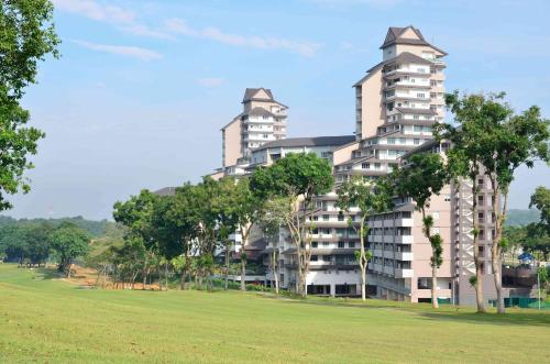 un gran edificio de apartamentos con árboles frente a un campo en Amansari Residence Resort, en Johor Bahru