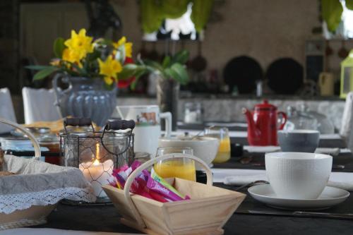 een eettafel met een kaars en bloemen erop bij Aux Greniers à Rêves in Plestan
