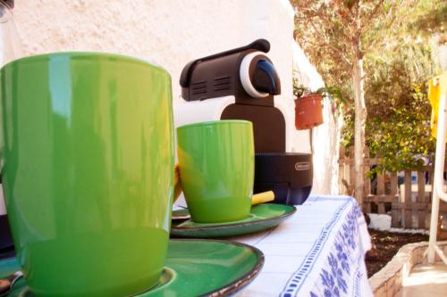 two green cups sitting on top of a table at B&B Lety in Alghero