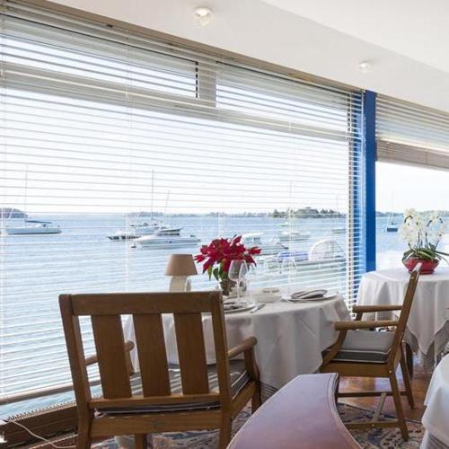 une salle à manger avec une table et une grande fenêtre dans l'établissement Hotel Restaurant Les Venetes, à Arradon