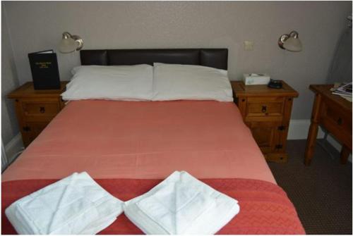 Schlafzimmer mit einem Bett mit einer roten Tagesdecke in der Unterkunft Queens hotel in Wick
