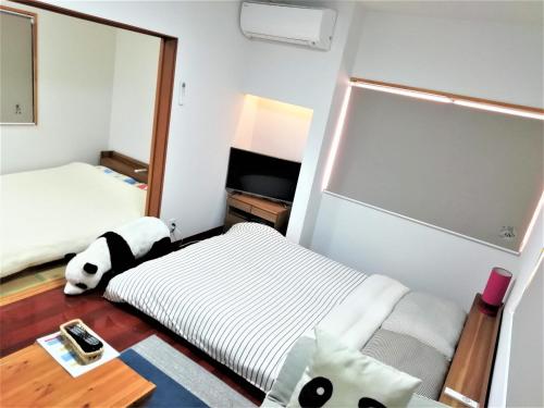 a small room with two beds and a mirror at Panda Stay Okayama in Okayama