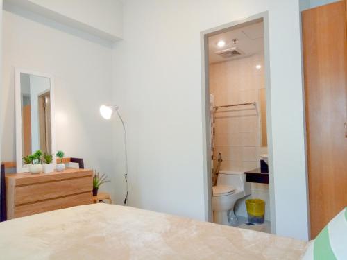 a bedroom with a bathroom with a toilet and a sink at Forbes Area BGC Taguig Manila in Manila