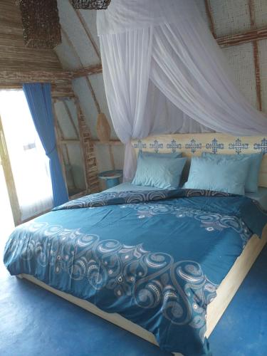 a bedroom with a blue bed with a canopy at Casa Azzurra in Gili Air