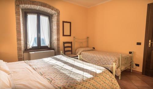 a bedroom with two beds and a window at Agriturismo Il Giardino Dei Ciliegi in Passaggio Di Assisi