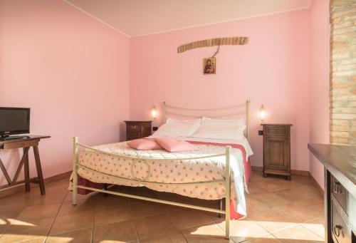 a bedroom with a bed with pink walls at Agriturismo Il Giardino Dei Ciliegi in Passaggio Di Assisi