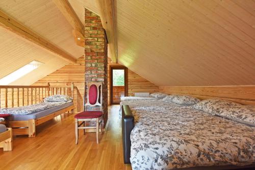 a bedroom with two beds in a log cabin at Auksinis Ąžuolas in Avižieniai