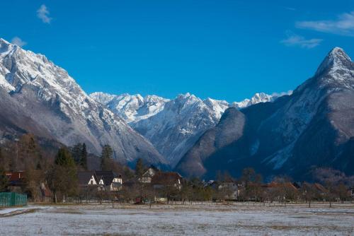 a village in front of a snowy mountain range at Chalet GoSlo in Srpenica