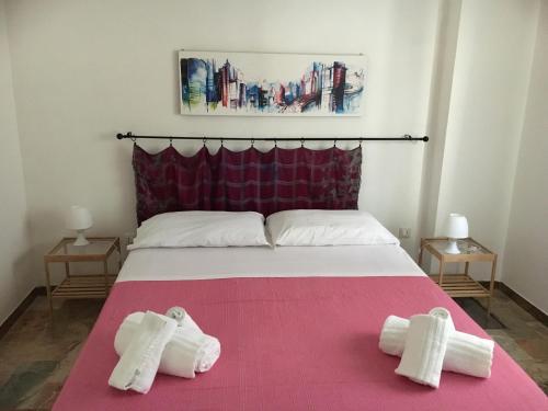 アルカモ・マリーナにあるCento Passi Dal Mareのベッドルーム1室(ピンクベッド1台、タオル付)