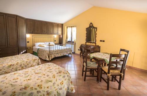 sypialnia z 2 łóżkami, stołem i krzesłami w obiekcie Agriturismo Il Giardino Dei Ciliegi w mieście Passaggio Di Assisi
