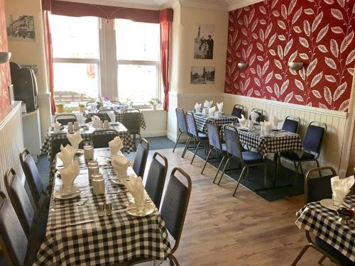 a restaurant with long tables and chairs and a room with tables and chairs at Hayward Hotel in Blackpool
