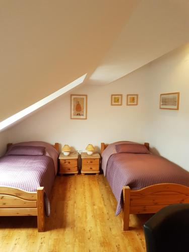 a attic room with two beds and wooden floors at Landhaus Warndtwald in Wadgassen