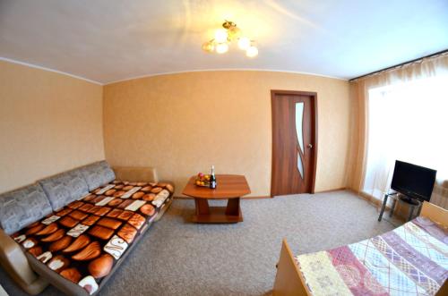 ケメロヴォにあるApartment on Krasnoarmeyskaya 95Aのベッドとテーブルが備わるホテルルームです。