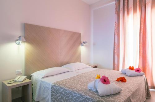 a bedroom with a bed with stuffed animals on pillows at Hotel Villaggio Cala Di Volpe in Capo Vaticano