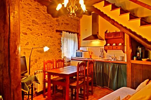 uma cozinha com mesa e cadeiras num quarto em Los Balcones del Río em Robledillo de Gata