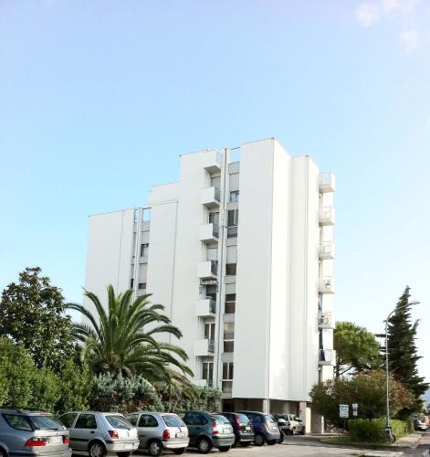 un edificio blanco con coches estacionados en un estacionamiento en Dormire a Cisanello, en Pisa