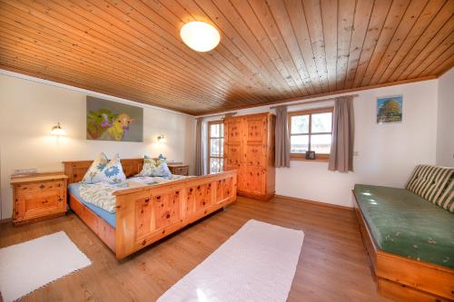 ein Schlafzimmer mit einem Bett und einem Sofa in einem Zimmer in der Unterkunft Peilberghof in Hollersbach im Pinzgau