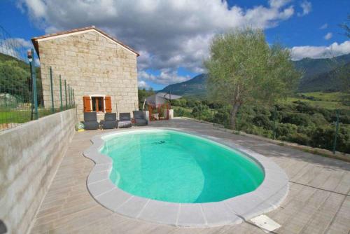 una piscina nel cortile di una casa di Maison de campagne, deux chambres, vue sur les montagnes a Sartène