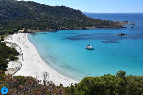 a boat in the water on a beach at Maison de campagne, deux chambres, vue sur les montagnes in Sartène