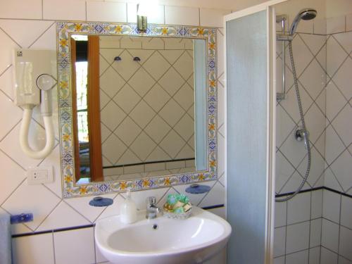 łazienka z umywalką i lustrem w obiekcie B&B Villa Maria Giovanna w mieście Giardini Naxos