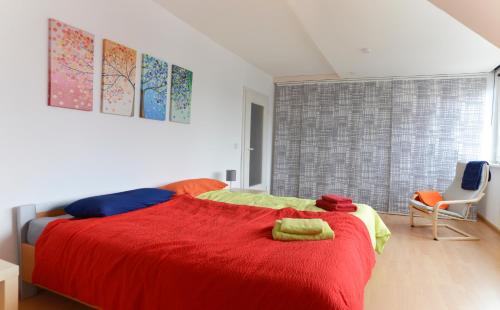 1 dormitorio con 1 cama roja y 2 toallas en flat2let Apartment 2, en Frankfurt