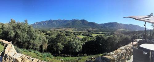 a view of a mountain from a stone wall at Maison de campagne, deux chambres, vue sur les montagnes in Sartène