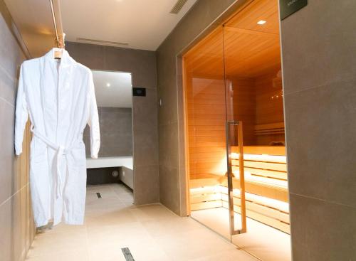 a robe hanging in a bathroom with a walk in shower at Hotel De La Ville in Riccione
